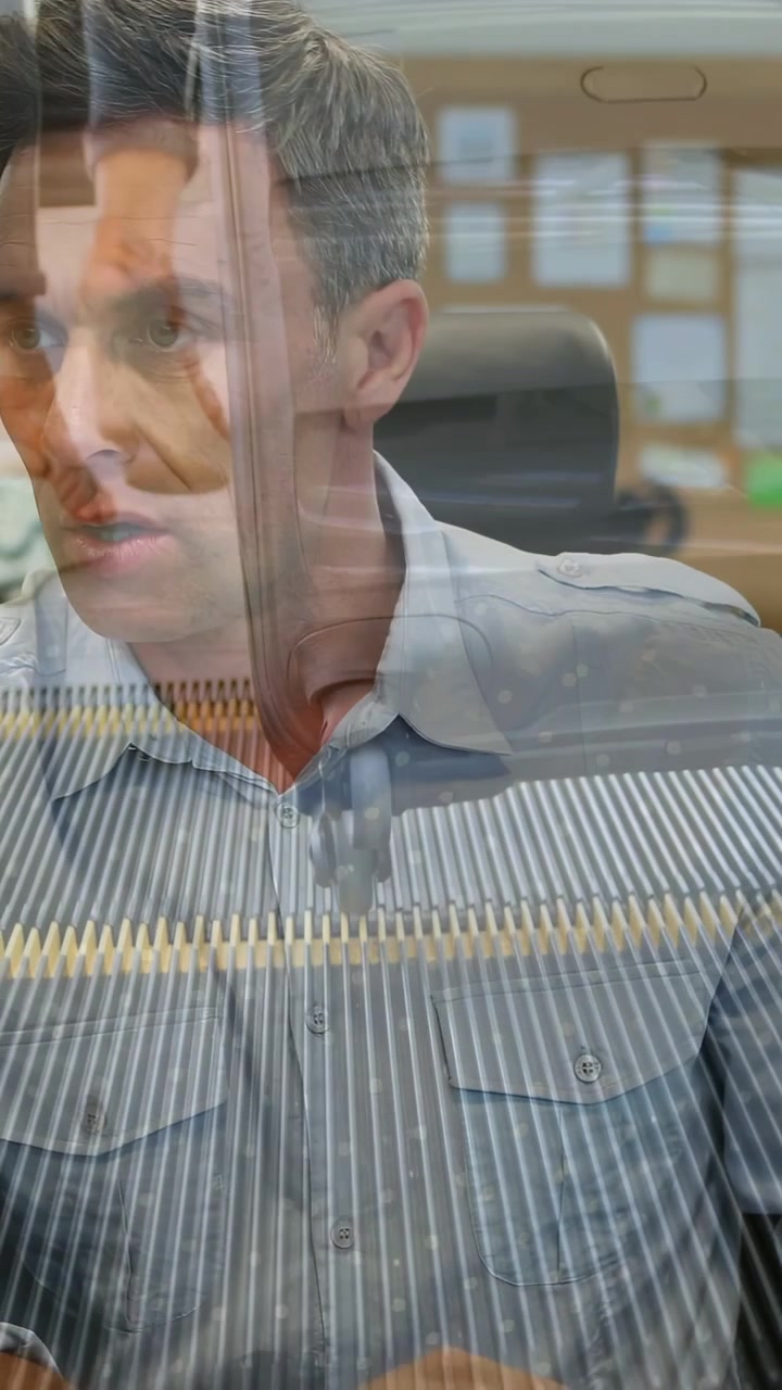 Video verticale: Uomo che osserva e poi si china alla scrivania dell'ufficio, leggendo documenti con una leggera sovrapposizione per la revisione.