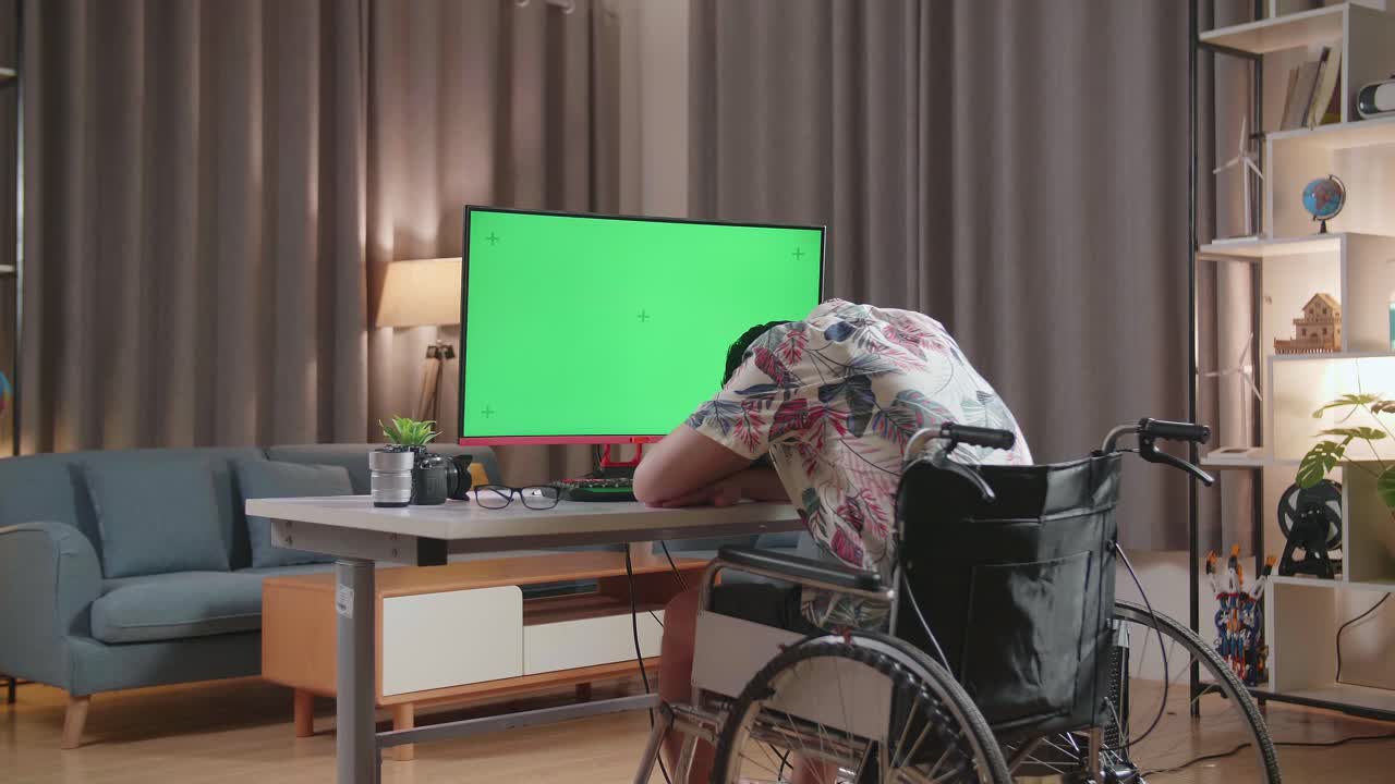 Tired Person in Wheelchair with Green Screen Computer Monitor