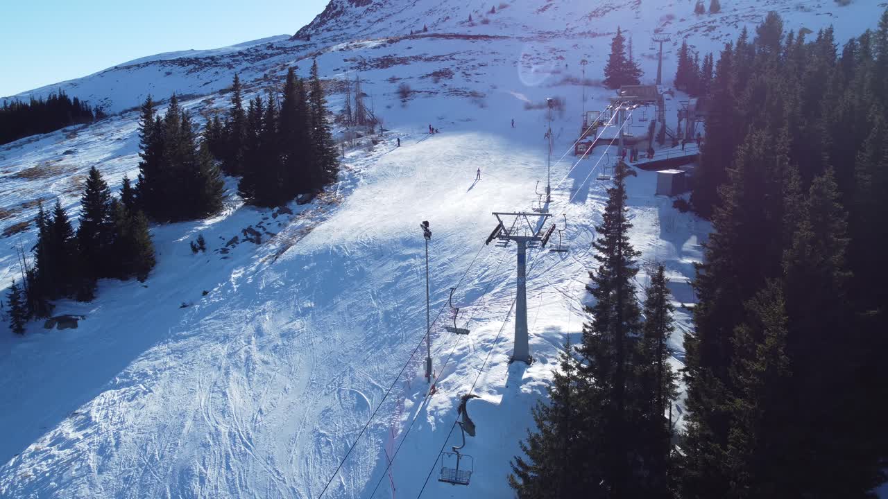 статический воздушный клип людей, катающихся на лыжах по горному склону на солнце в горнолыжном курорте витоша недалеко от софии, болгария с креслом, работающим на переднем плане