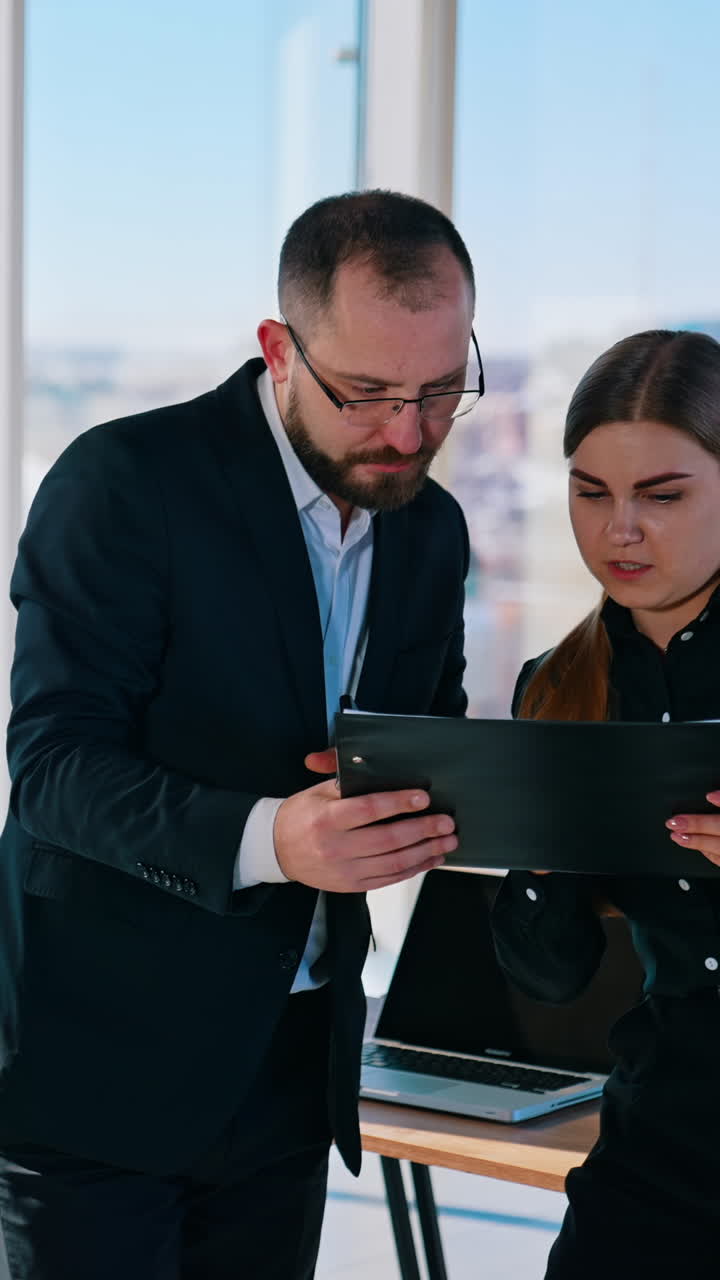 Young creative coworkers working with new startup project in office. Vertical video