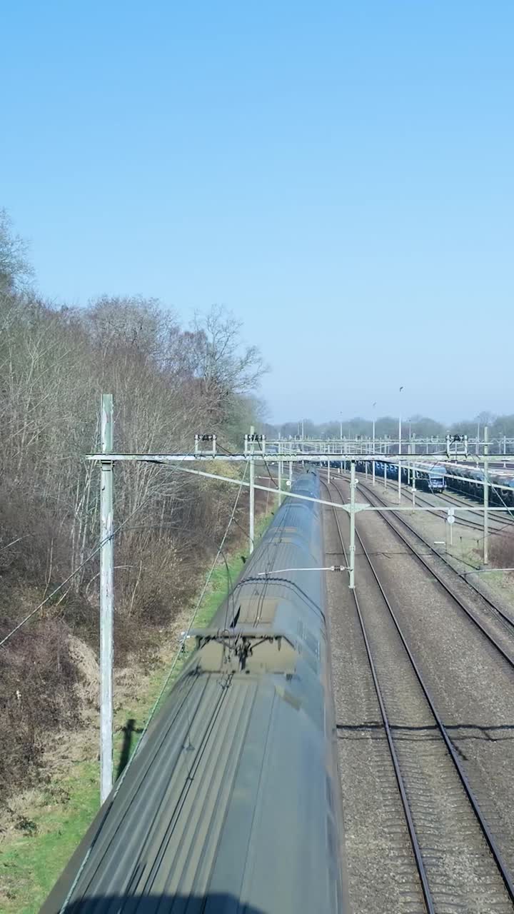 Modern Passenger Train Traveling on Multiple Railway Lines on a Sunny Day