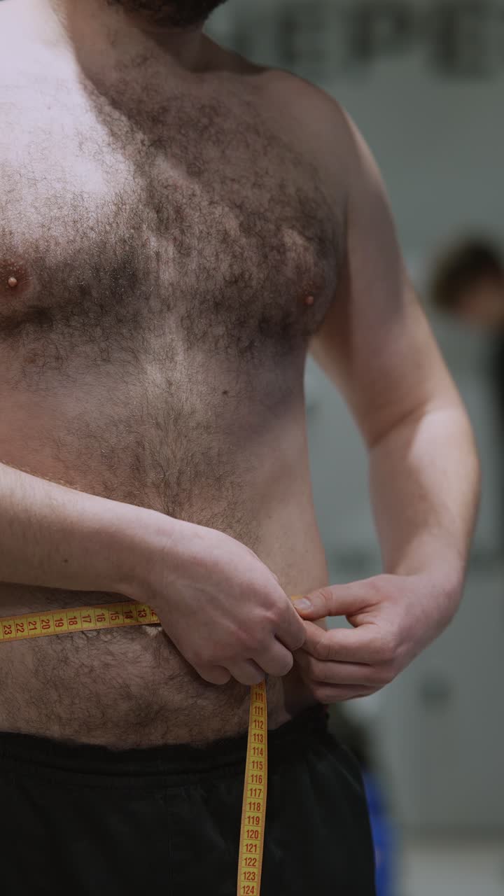 hombre midiendo la cintura con una cinta métrica