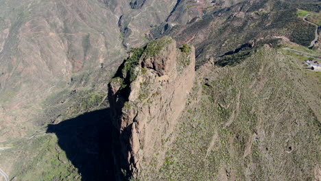 aerial circle view over on side of roque nublo, on a bright, sunny day