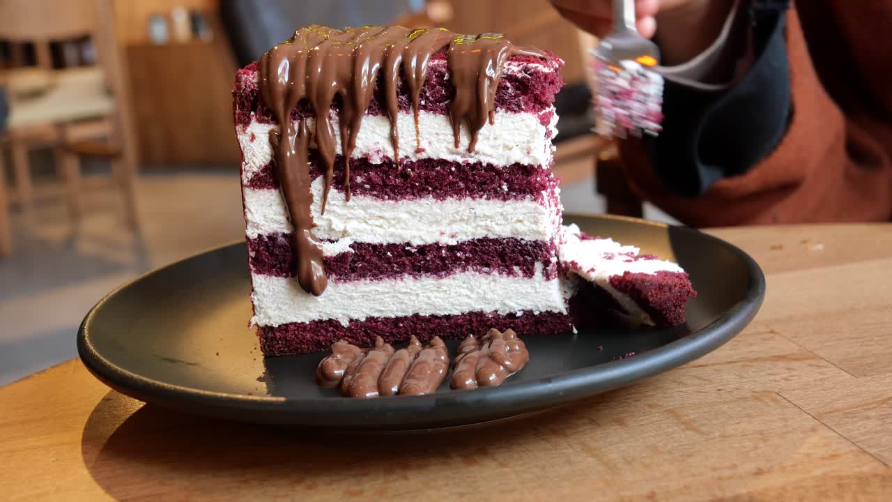 una rebanada de pastel de terciopelo rojo con salsa de chocolate