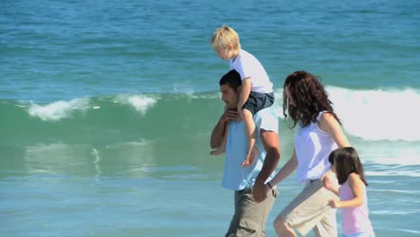 Nette-Familie,-Die-Am-Meer-Entlang-Spaziert