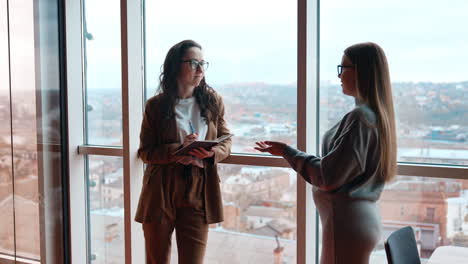 business communication in the office, exchanging ideas, brainstorming, finding solutions. two ladies in office cheerfully talk.
