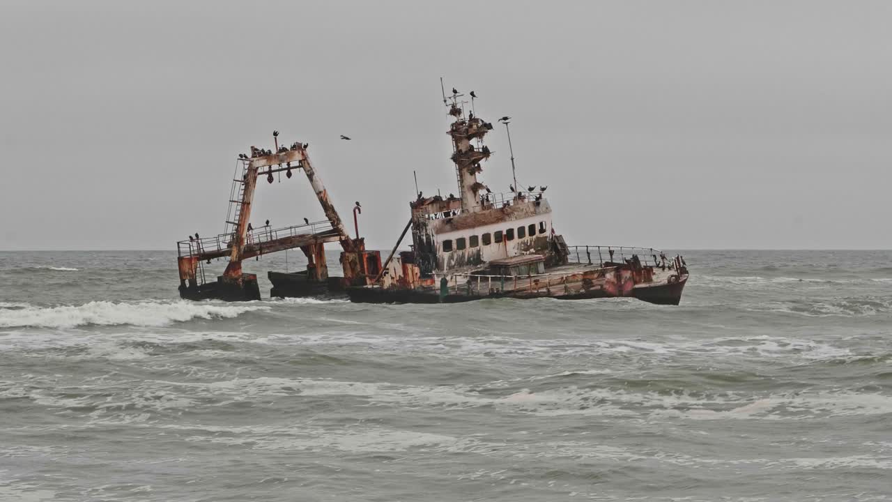 Zeila shipwreck in grey ocean waves along Namibia Skeleton Coast, Wide Shot