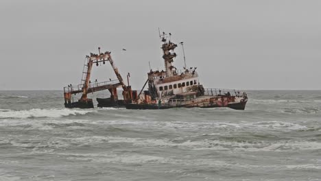 zeila shipwreck in grey ocean waves along namibia skeleton coast, wide shot