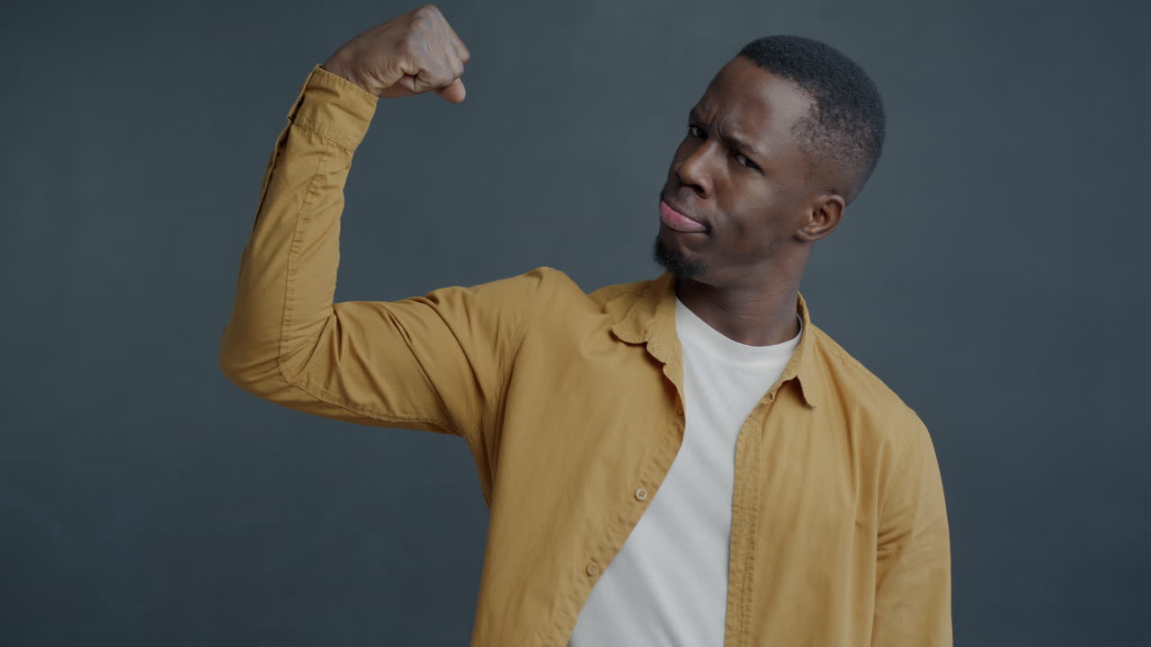 Man flexing muscles in a yellow shirt