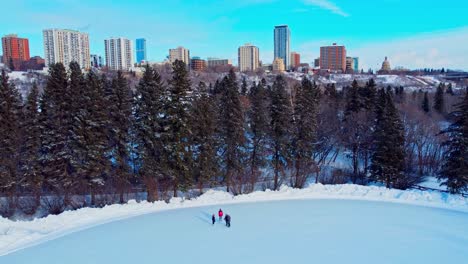 el frío extremo del invierno en la pista de patinaje del parque victoria dobla algunas personas patinando a menos 30 a 40 grados centígrados por la tarde con un horizonte de fondo con vista a la legislatura hendrix crestview tower condominios edm1-4