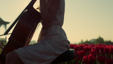 Closeup-unknown-girl-playing-cello-in-blooming-summer-garden-in-sun-reflection.