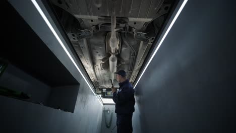 inspección del tren de aterrizaje del automóvil por parte de un mecánico