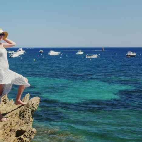 una mujer con un vestido de verano se encuentra en la playa