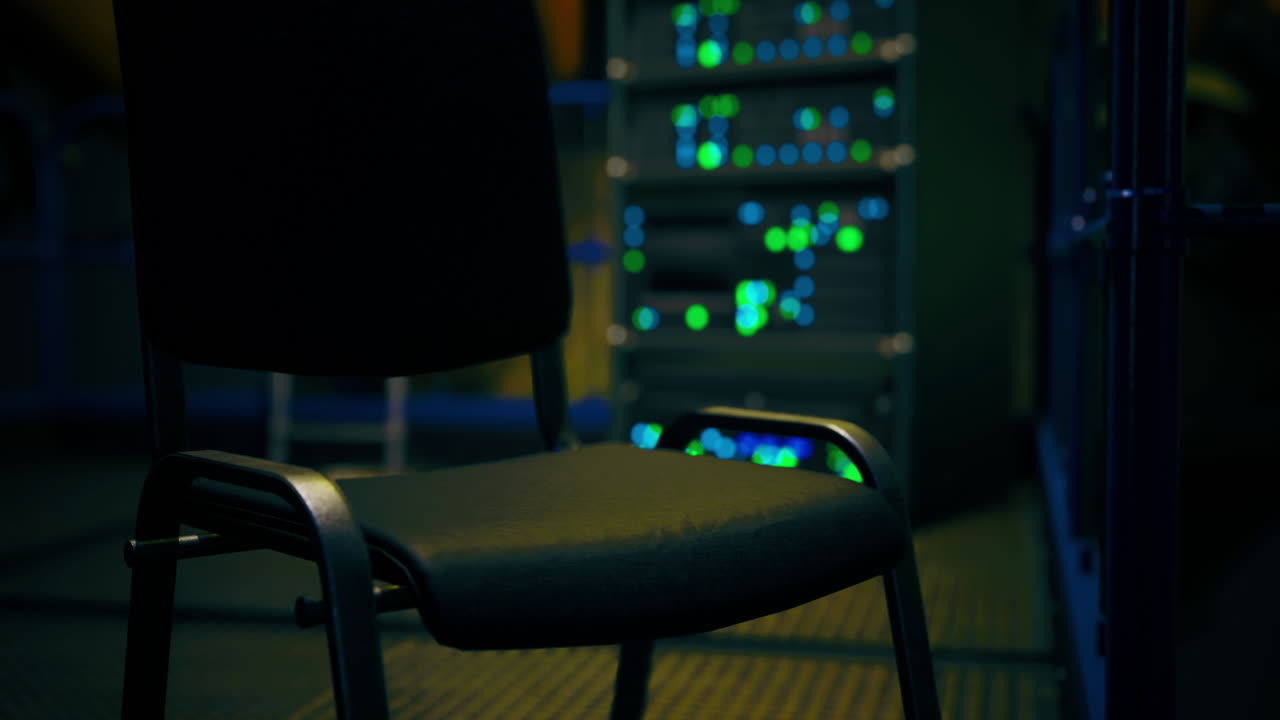 Mysterious chair sits in the shadows of a dimly lit server room at night