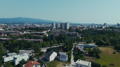 aerial - zagreb cityscape with mix of tall buildings and low-rise homes backed by distant hills