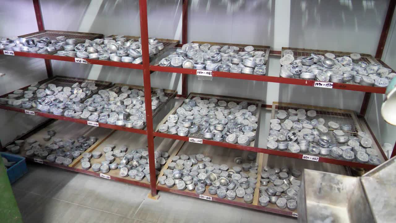 A shelf stacked with diamond grinders and polisher tools in a lens factory. The organized arrangement of equipment highlights the precision tools used in lens crafting. Jiangsu Province, China.