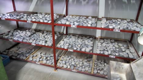 a shelf stacked with diamond grinders and polisher tools in a lens factory. the organized arrangement of equipment highlights the precision tools used in lens crafting. jiangsu province, china.