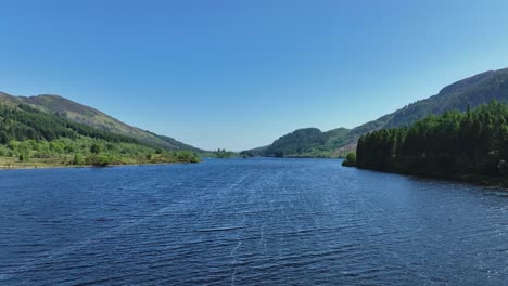 Aerial-Fly-Along-Scottish-Loch-near-Aberfoyle-in-the-Trossachs-Region-of-Central-Scotland-on-a-Sunny-Summers-Day