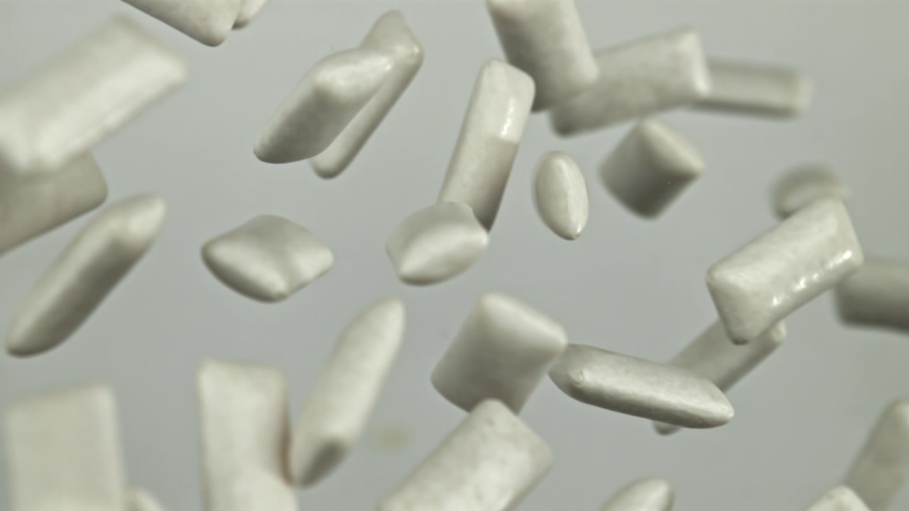 Palline di gomma da masticare bianche che cadono al rallentatore