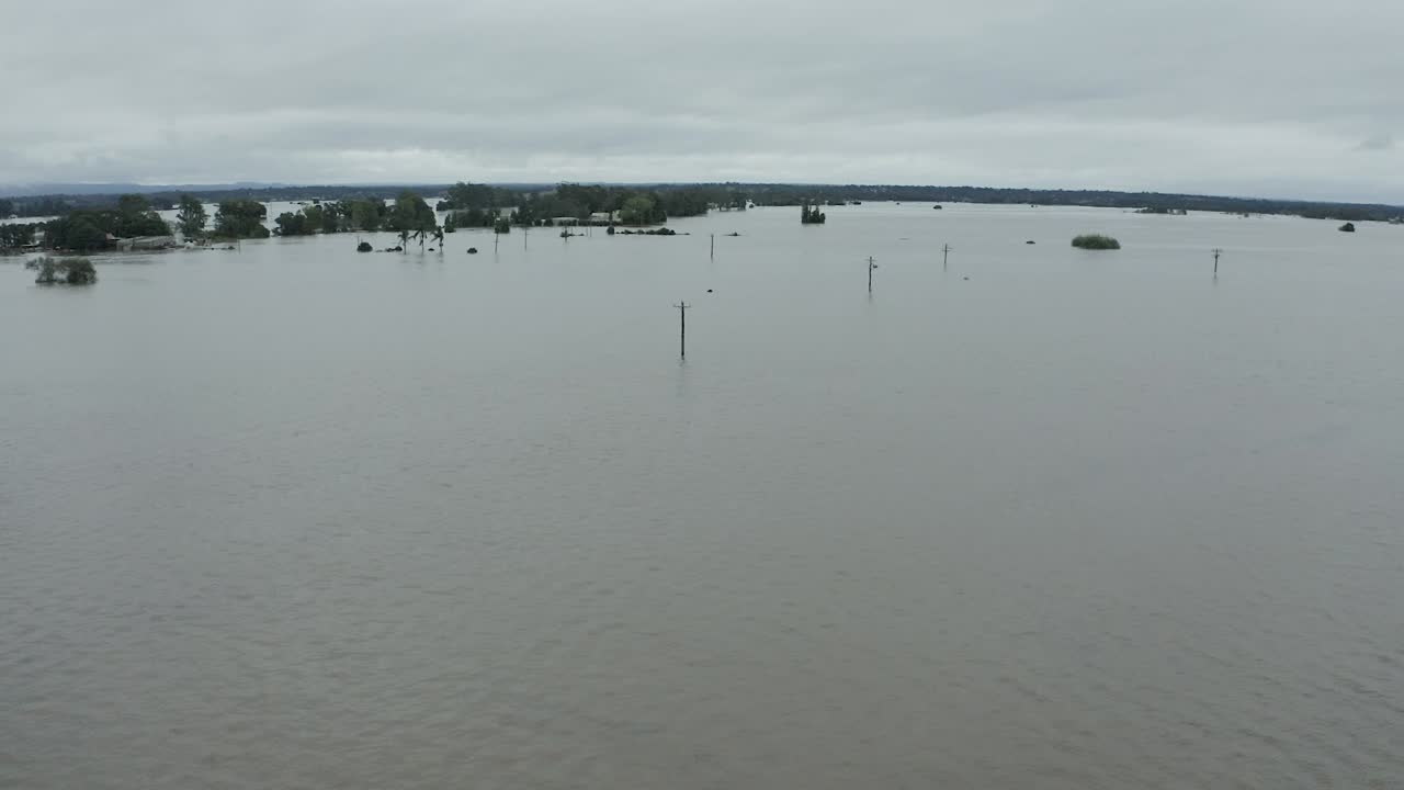 Fully submerged street aerial view with only the telegraph poles showing above the flood