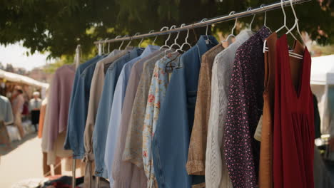 clothing displayed on a rack at an outdoor market