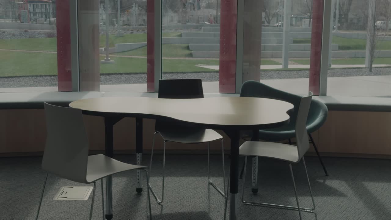 Slow motion left to right pan of study table by windows ending behind wall