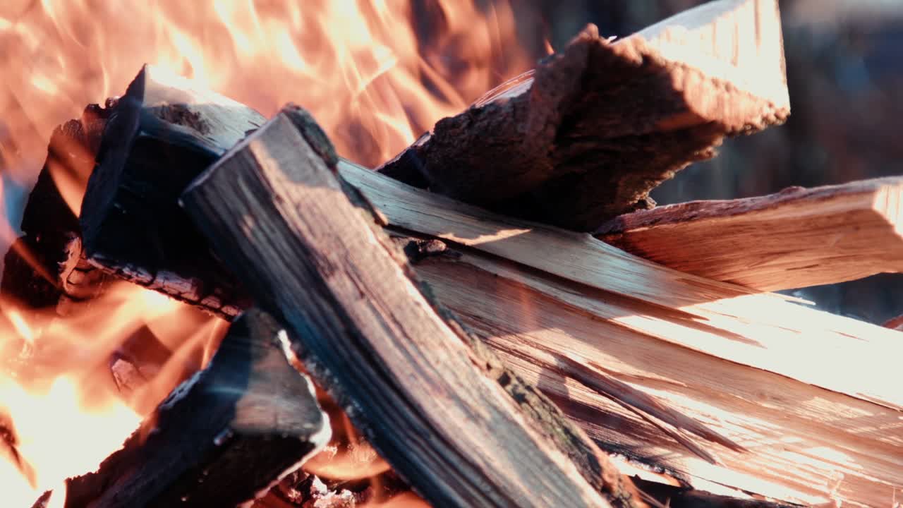Meat skewers and traditional boerewors on grid turned during open fire barbecue