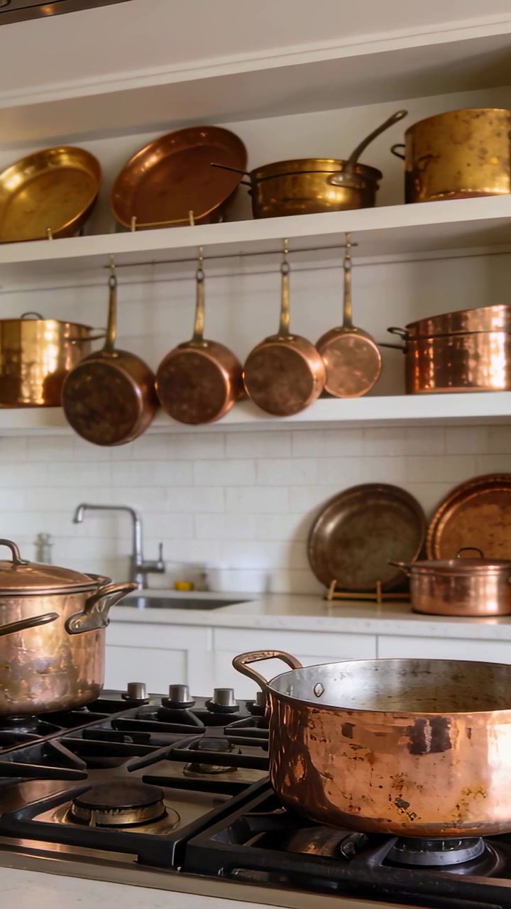 Vertical video: Panning camera starting on clip focusing on copper saucepan in kitchen showing pans