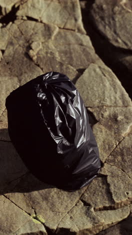 a black plastic bag on a rocky surface