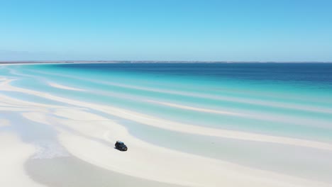 Excelente-Toma-Aérea-De-Una-Camioneta-Estacionada-En-Las-Arenas-Blancas-Cerca-Del-Agua-Azul-Clara-De-La-Playa-Flaherty-En-La-Península-De-Yorke,-Australia