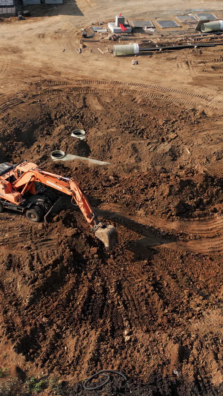 Excavator digging in a large pit at a construction site