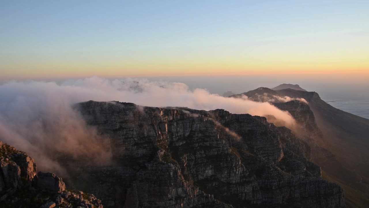 nubes sobre la montaña de la mesa, conocida como el mantel, durante la puesta de sol sobre el lado de los doce apóstoles