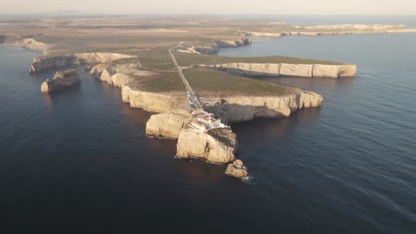 Aerial-depicting-the-long-straight-road-leading-towards-the-Sagres-lighthouse-overseeing-the-Atlantic-ocean-in-Portugal