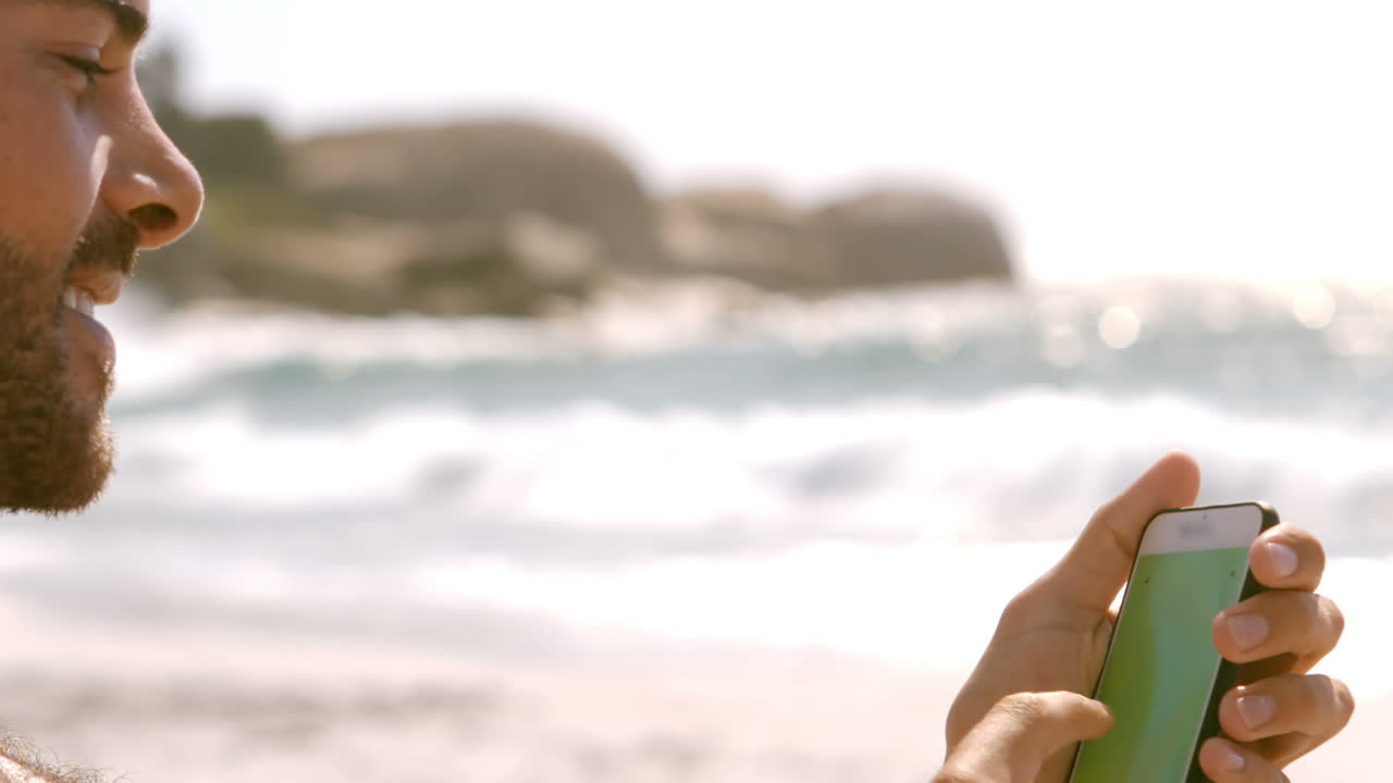 한 남자가 드폰을 쳐다보고 있다.