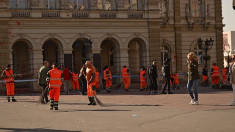 city workers cleaning up graffiti and damage after a protest