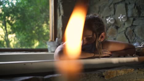 mujer joven y atractiva que tiene un baño elegante en un jacuzzi preocupada triste con una máscara covid con una gran ventana verde de la naturaleza capaz de cámara lenta 60fps 3