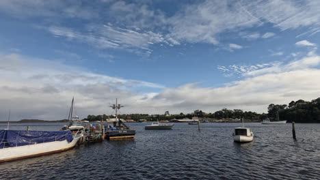 boats floating on the water on a sunny day in strahan, west coast of tasmania