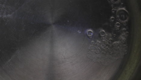 water's boiling on the hot pan, and tiny bubbles are popping up all over the place