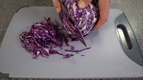 7/8-Ansicht-Eines-Mannes,-Der-Rotkohl-In-Einer-Küchendraufsicht-Schneidet