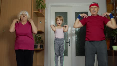 active senior couple grandmother grandfather with child kid girl doing fitness stretching exercises