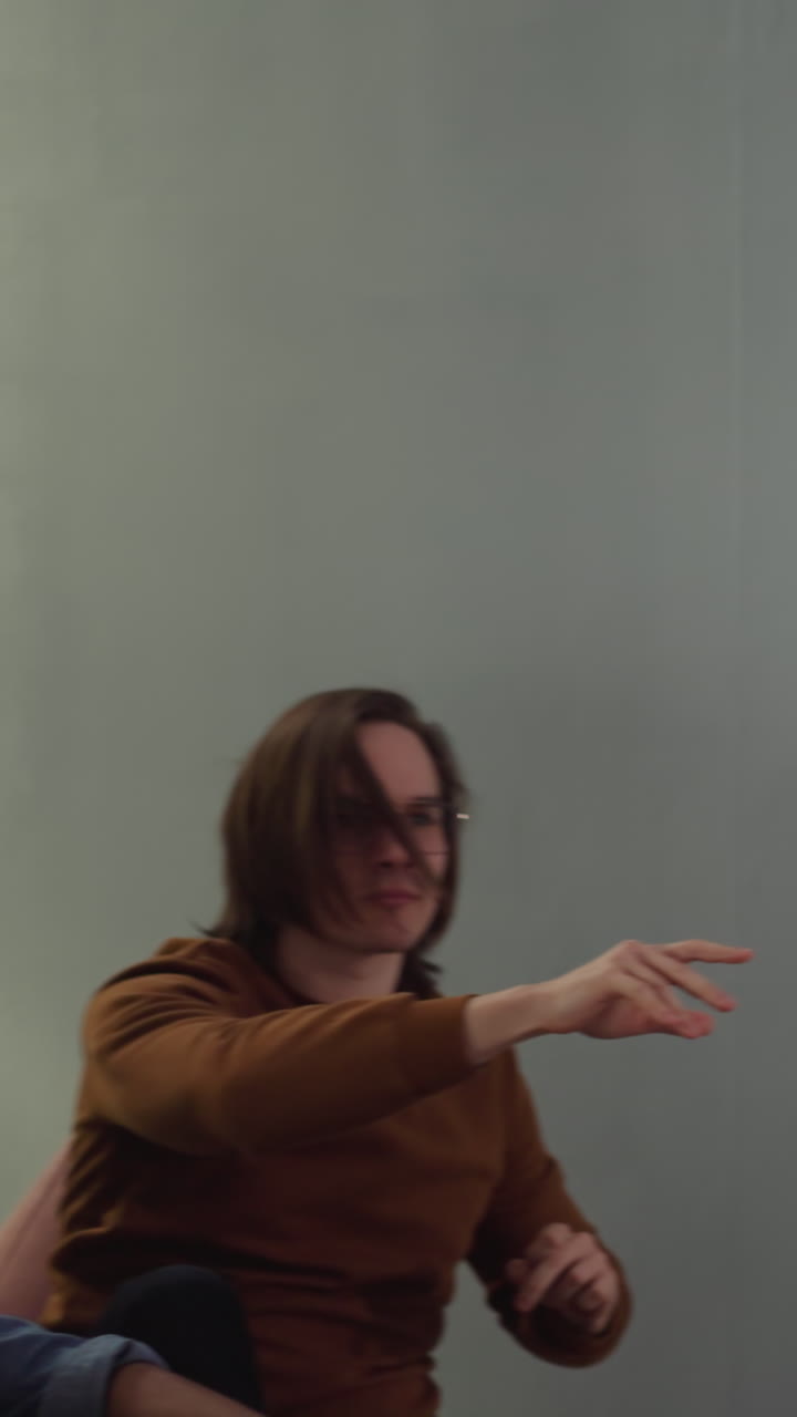 un hombre enojado daña la pantalla del televisor con el control remoto rebotado después de la derrota del equipo de béisbol en el apartamento a cámara lenta. amigos conmocionados se preocupan por el fracaso en el campeonato