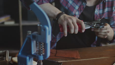 Leather manufacturer making holes in leather strap. Leather workshop