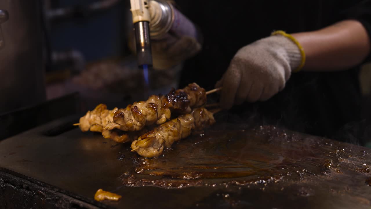 Cuocere spiedini di carne su una griglia a fiamma viva