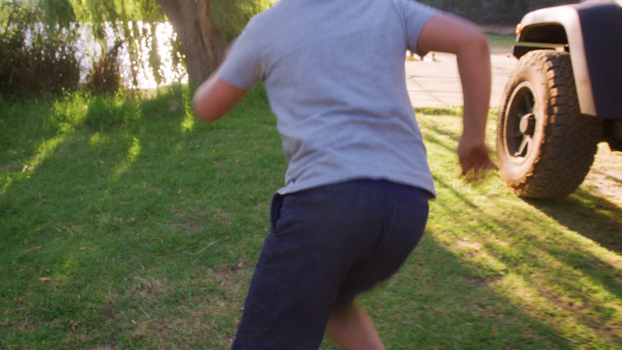 두 아이가 차 밖으로 뛰어내려 해가 지면 호수에 있는 부두로 달려갑니다.