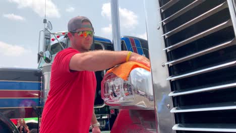 trucker polishes grill on semi tractor trailer diesel truck