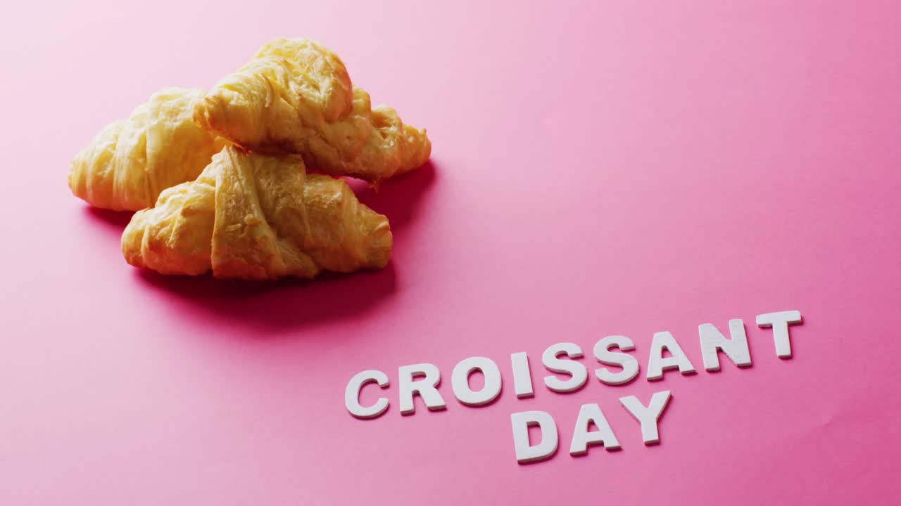 Vidéo en gros plan de croissants et du texte "Jour du croissant" sur fond rose