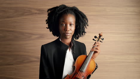 portrait of classical musician holding violin african american woman