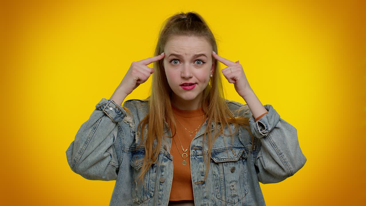 젊은 여성이 생각하고 그녀의 머리를 가리키고