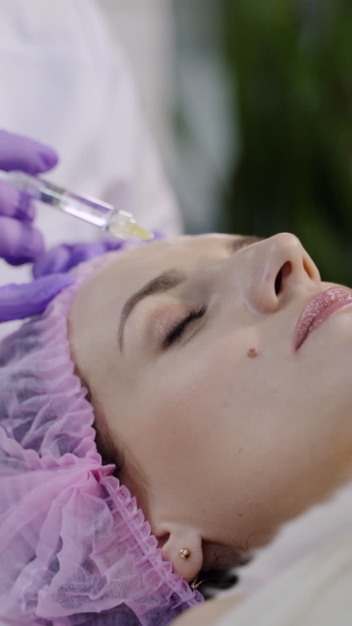 Hands of cosmetologist making injection in face. Aesthetic cosmetology. Vertical video