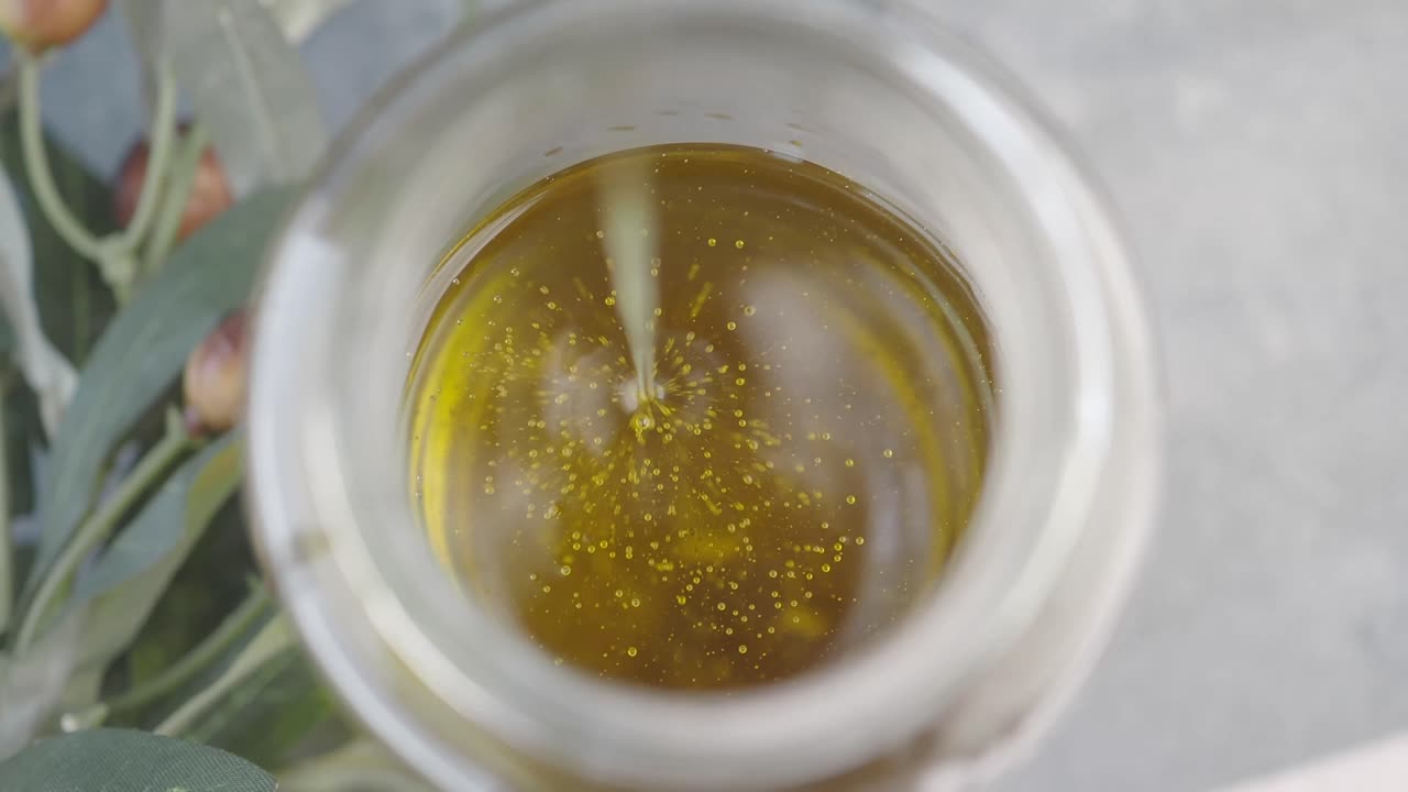 Pouring Olive Oil into a Jar